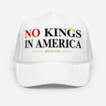 Front of No Kings In America white foam trucker hat showing large script design printed in red and white font.