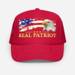 Front of Real Patriot USA Flag Eagle red trucker hat showing printed flag and eagle design. Real Patriot in gold-colored font