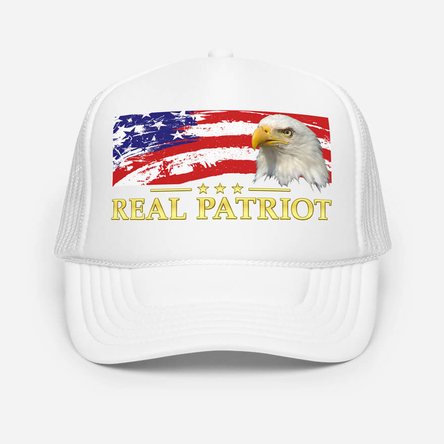 Front of Real Patriot USA Flag Eagle white trucker hat showing printed flag and eagle design. Real Patriot in gold-colored font